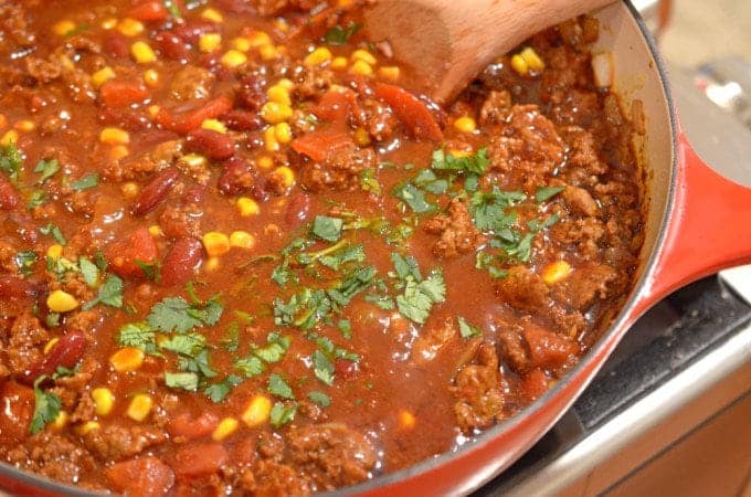 A skillet with chili and corn