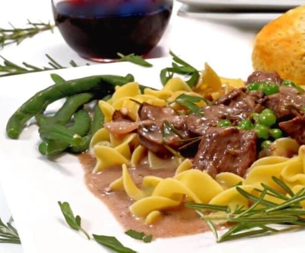 A plate of beef tips with noodles