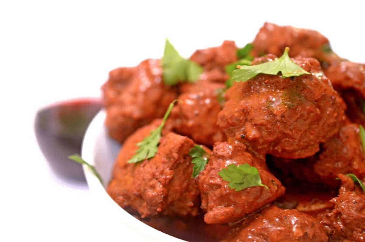 Bowl of meatballs with a glass of red wine.