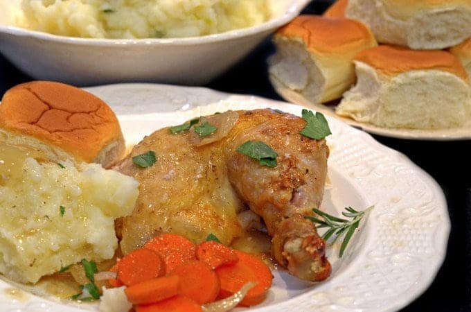 a chicken thigh with carrots on a plate