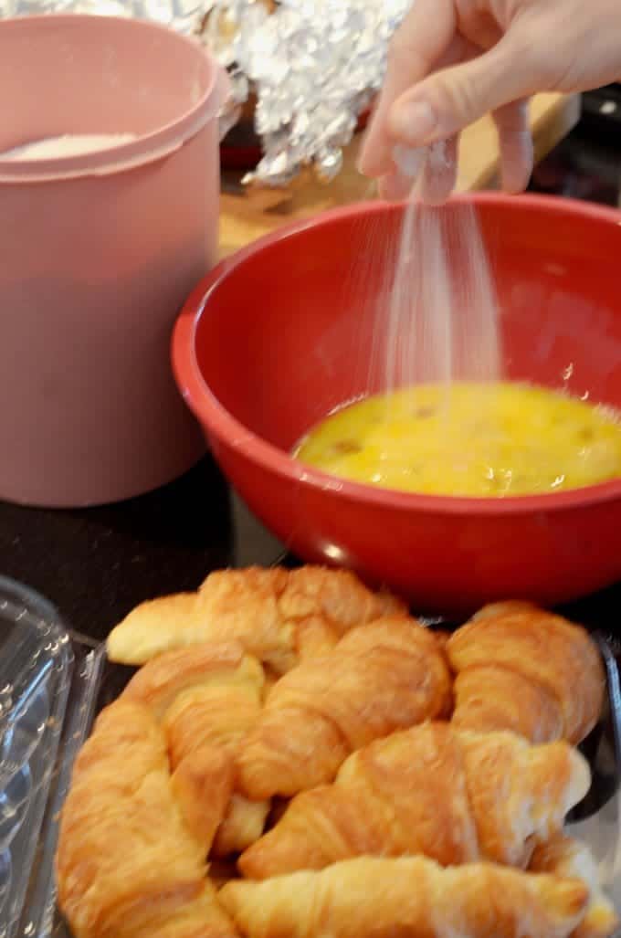 Adding sugar to a bowl of beaten eggs