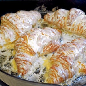 A pan of food on a plate, with Almond and Croissant