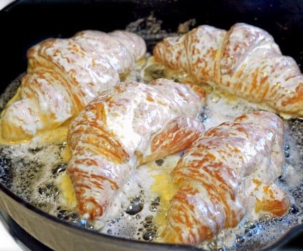 A pan of food on a plate, with Almond and Croissant