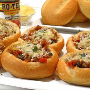bread bowls filled with sausage and parmesan on a plate.