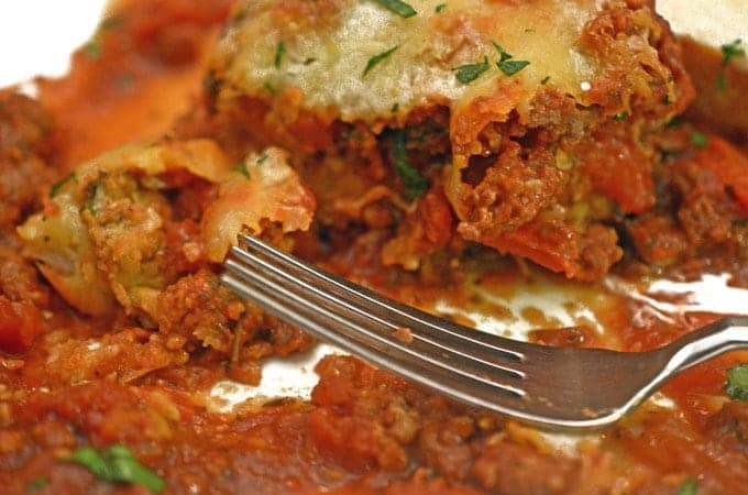 A close up of a plate of food with a fork, with Eggplant