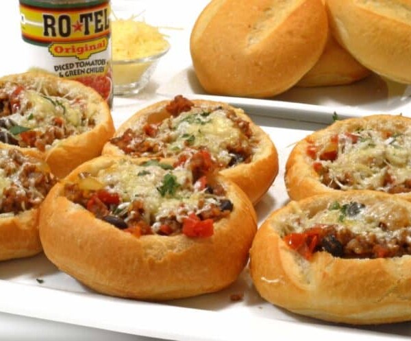 bread bowls filled with sausage and parmesan on a plate.