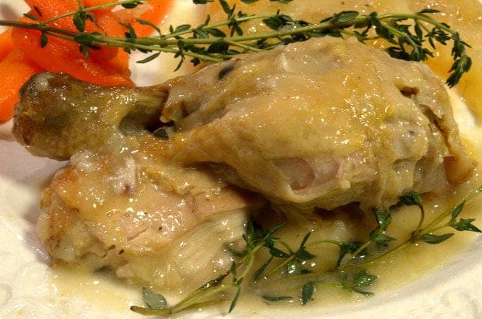 a close up of two chicken drum sticks with gravy