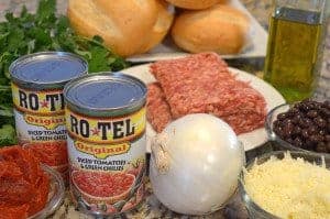 sausage, onion and a can of tomatoes on the countertop.