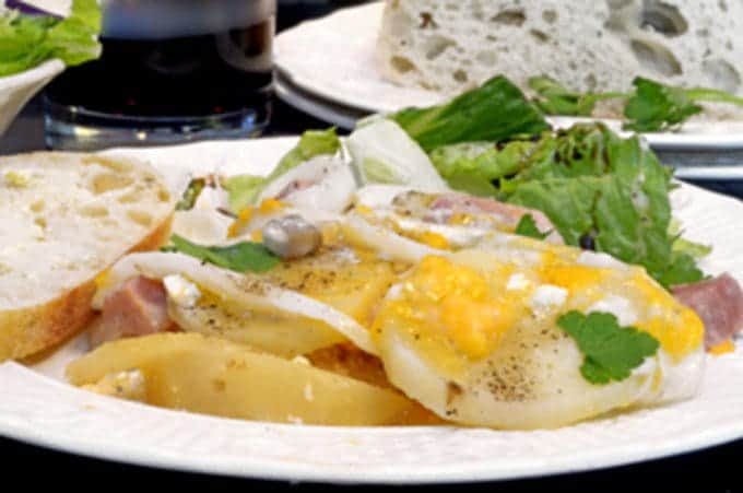 A plate of food on a table, with scalloped potatoes 