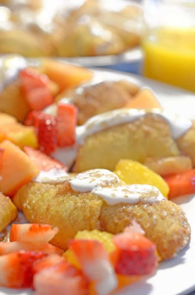 A plate of food with fruit and a croissant