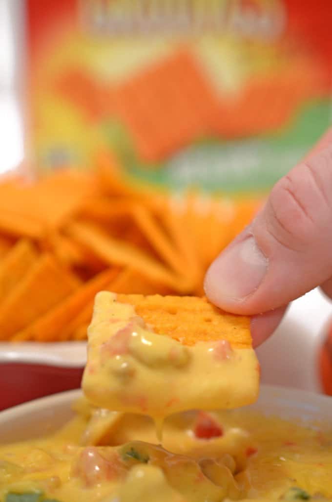A close up of a person holding a plate of food, with Cheez-It and Cheese