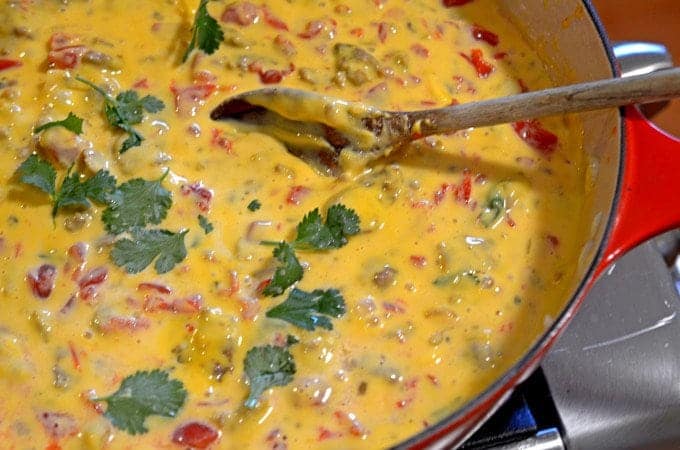 A pan of cheese dip with wooden spoon