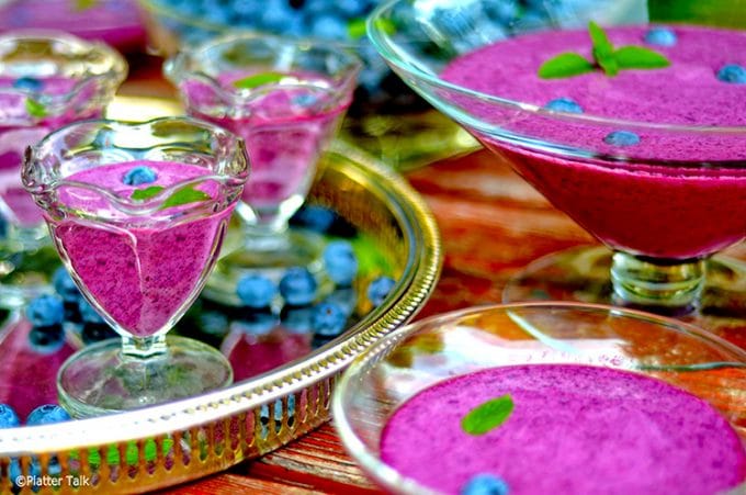 tray of blueberry soup with mint leaves.