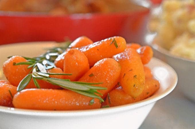 A bowl of roasted carrots with rosemary