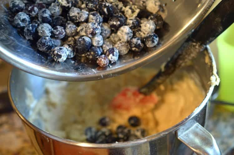 blueberries being mixed into the cake