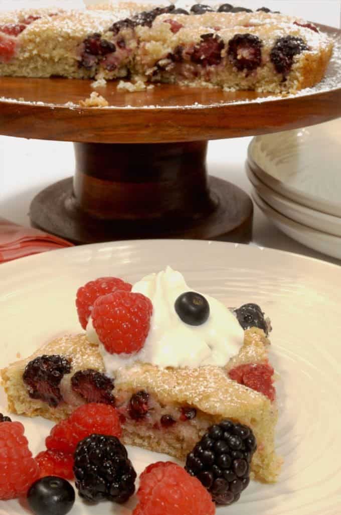 A slice of cake with whipped cream and berries