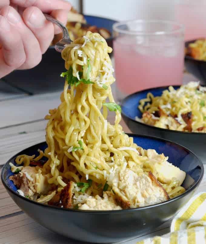 Eating chicken ramen noodles with a fork.