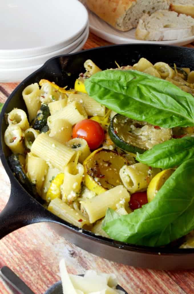 a bunch of food in a skillet with fresh basil