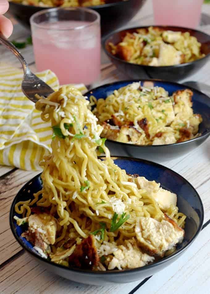 three bowls of ramen noodles with glass of pink lemonade.