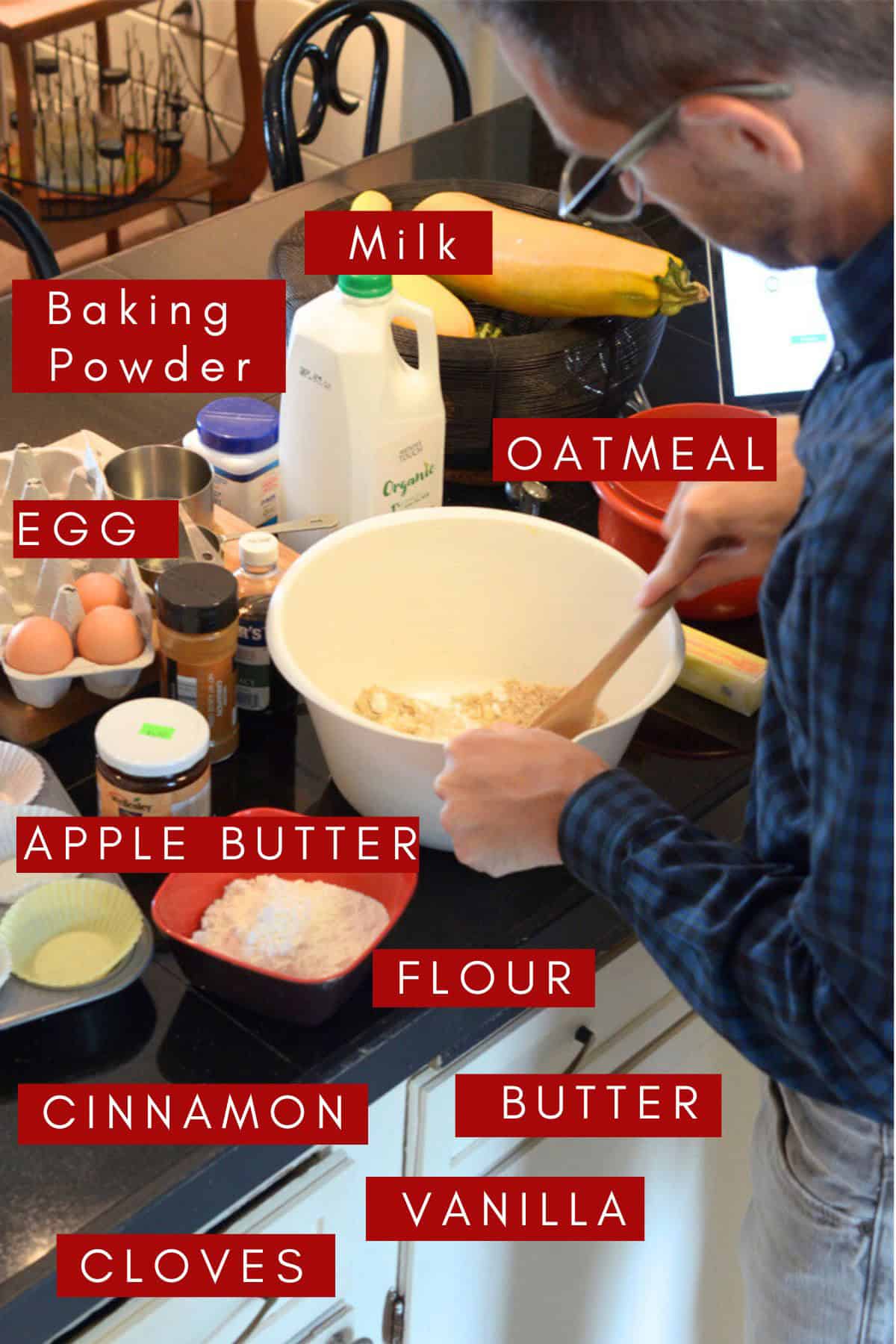 A man standing in the kitchen mixing up some apple butter muffins.