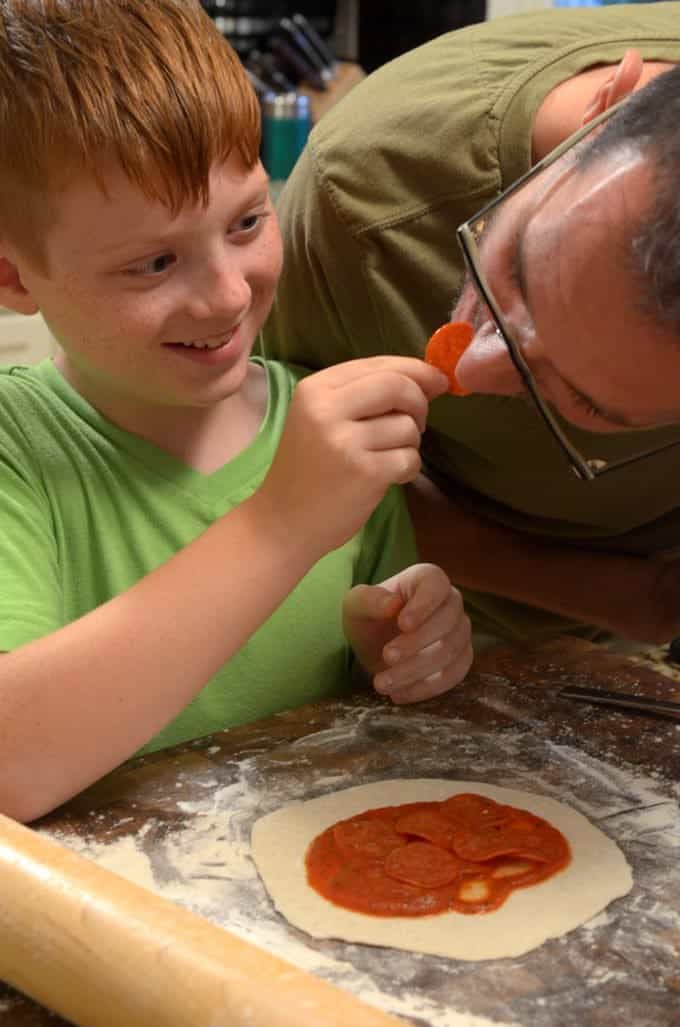 A young boy cooking with his father