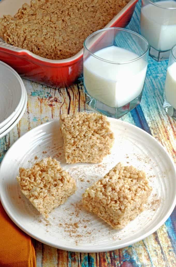 Rice krispie treats on a plate with a cup of milk