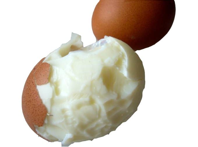 A hard-boiled egg with chunks taken out of it