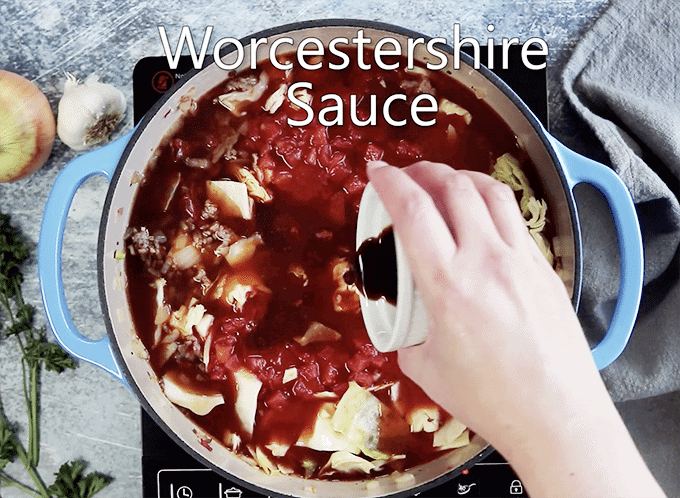 Worcestershire sauce being added to pot of cabbage and tomato