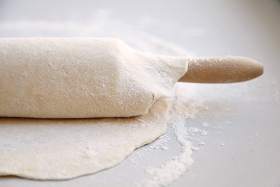 Rolling out a pie dough on a rolling pin