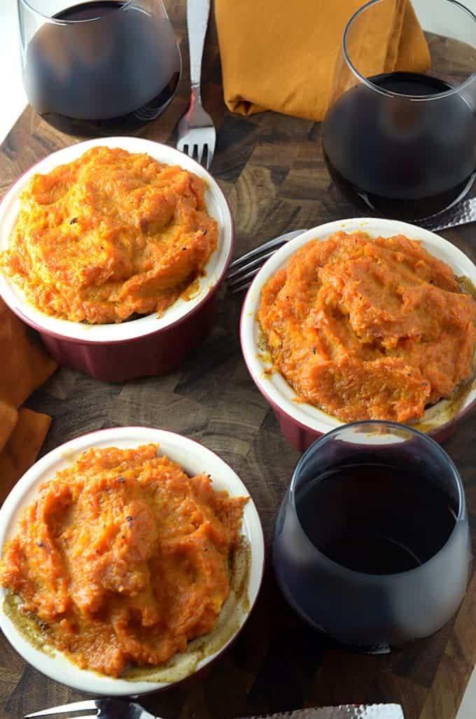 three bowls of food with wine on a table