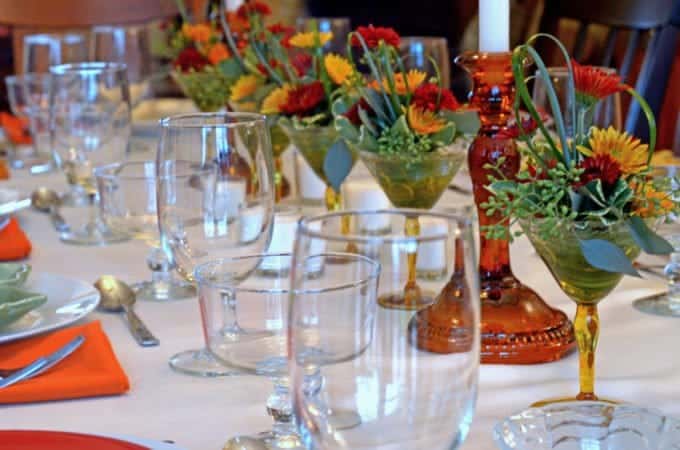 Thanksgiving tablescape with fresh flowers and wine glasses.