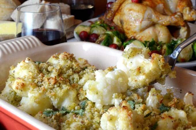 A close up of cauliflower gratin with background roast chicken