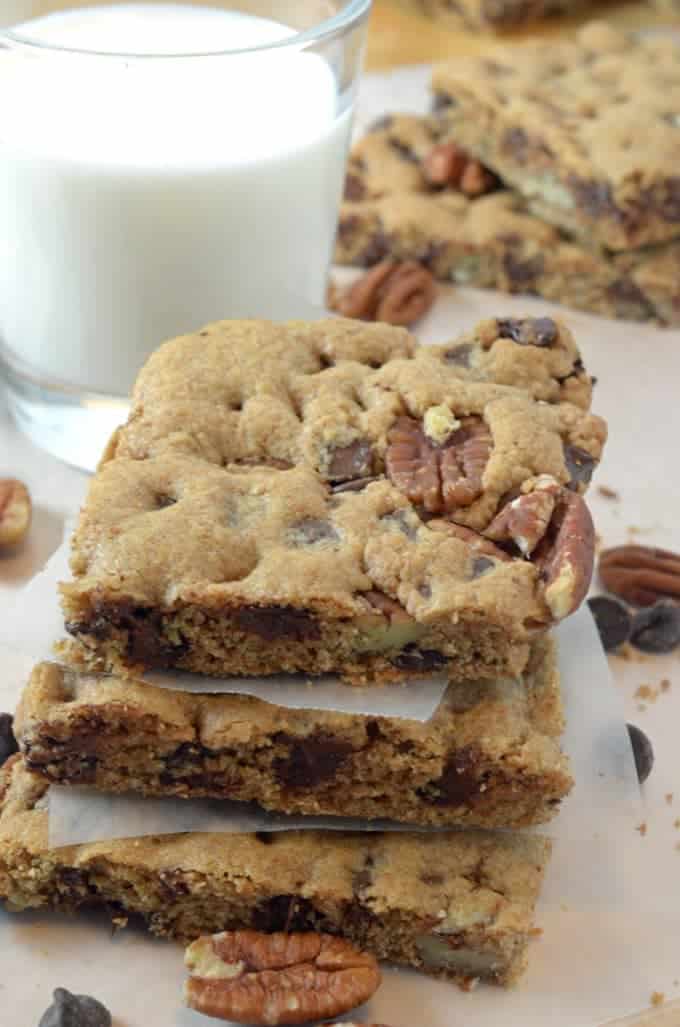 A stack of cookie bars with a glass of milk