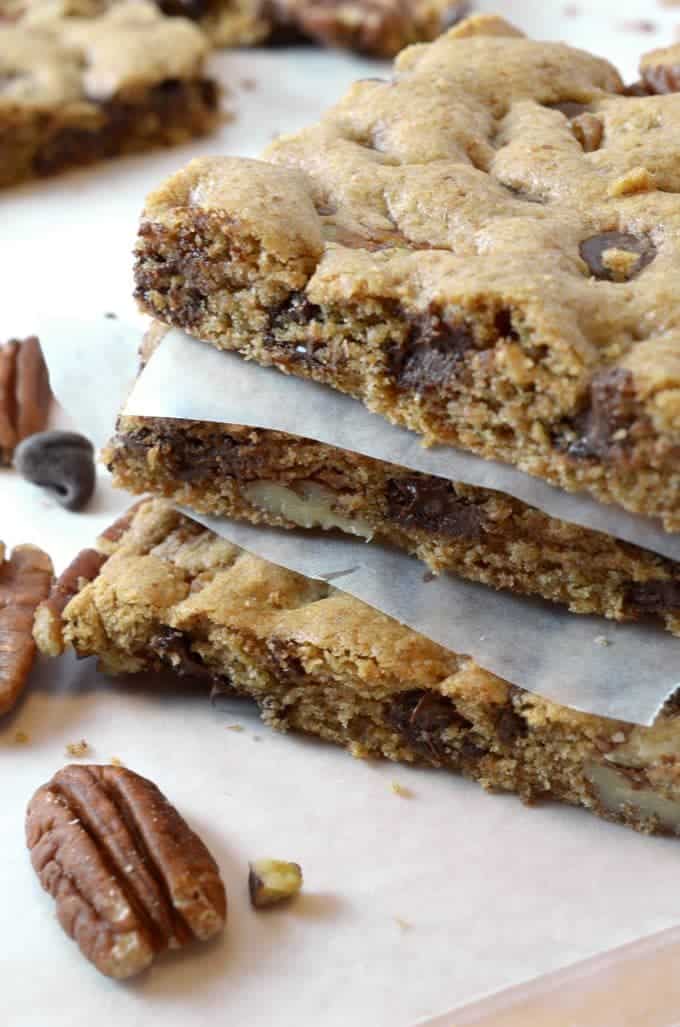 A close up of dessert bars with chocolate and pecans