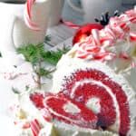 A festive red cake roll with a slice cut off.