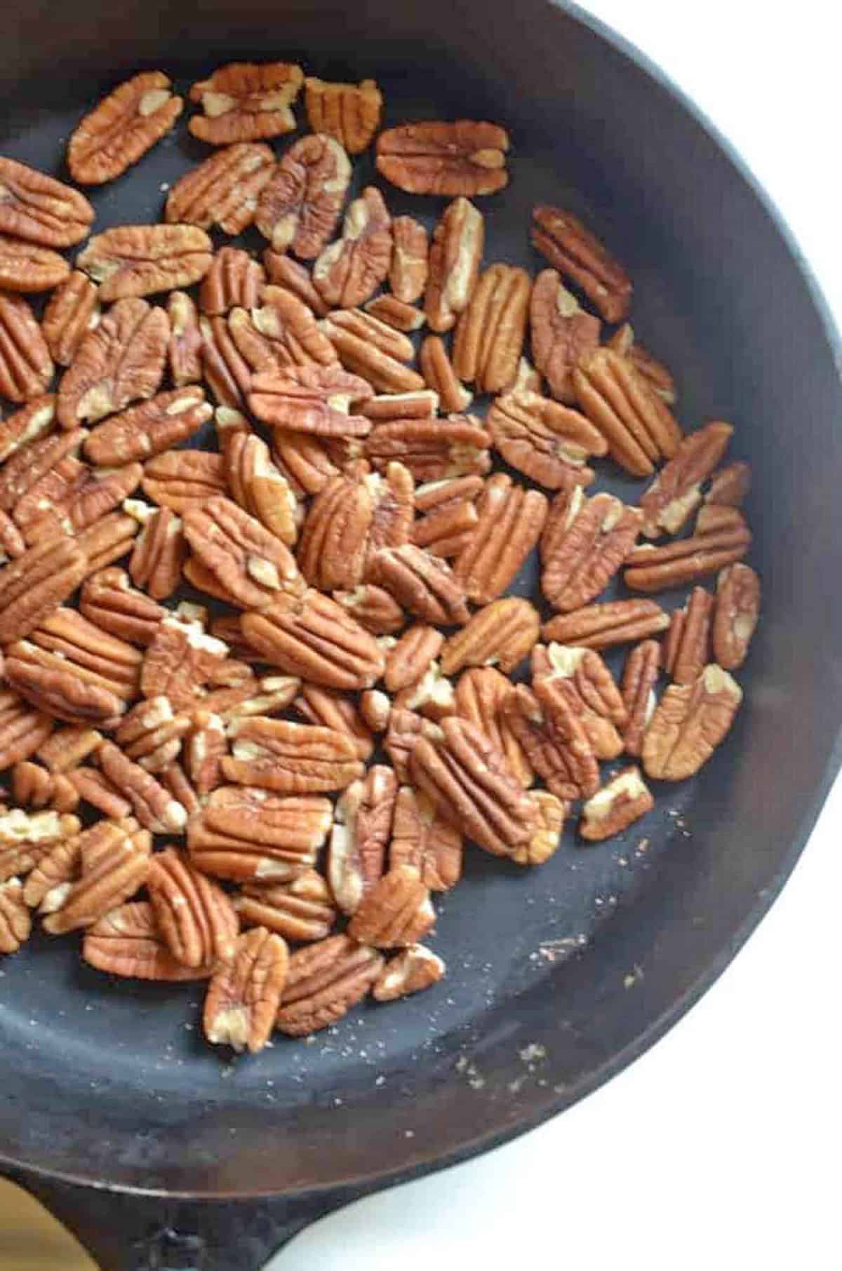 A skillet full of toasted pecans.