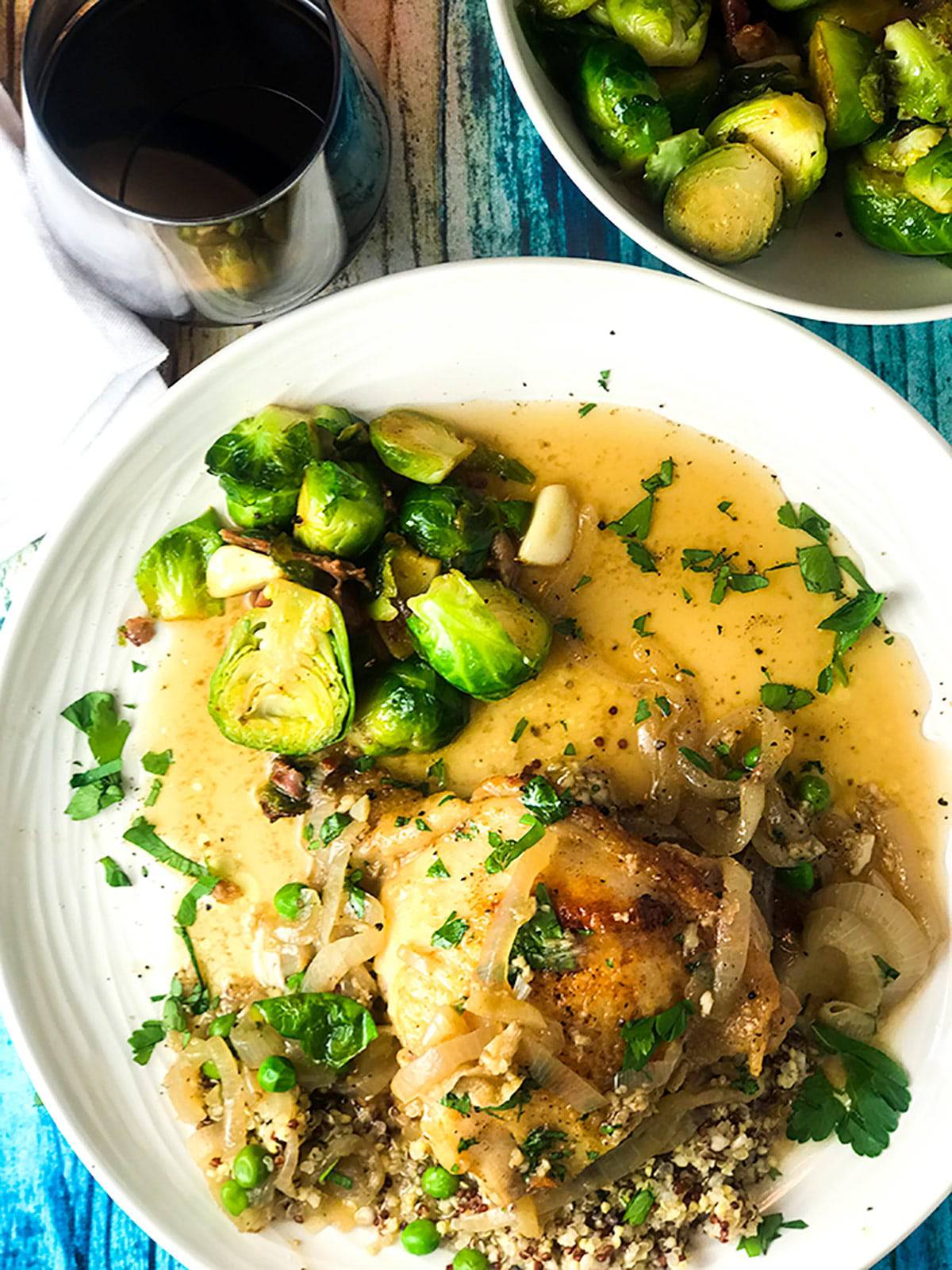 Plate of whiskey chicken in broth with Brussels sprouts.