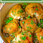 Skillet of chicken thighs with parsley garnish.