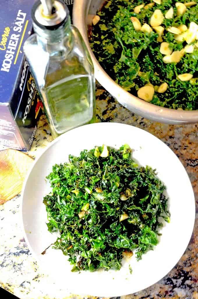 bowl of kale salad with olive oil, kosher salt, and fresh garlic.