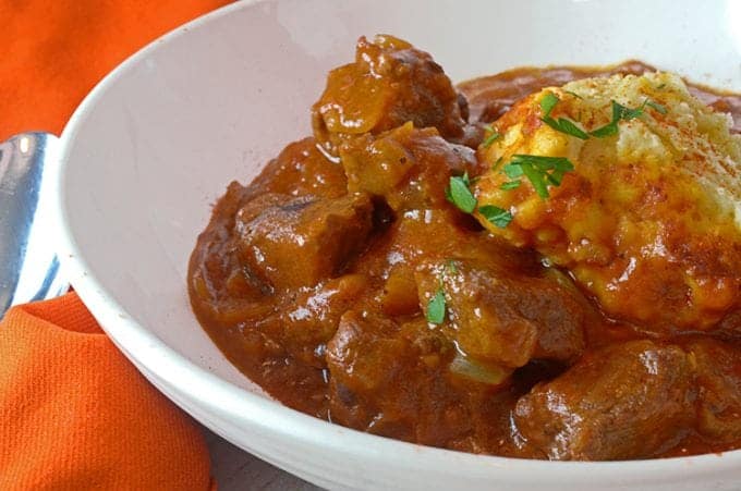 A close up of a plate of food with stew, with goulash and beef