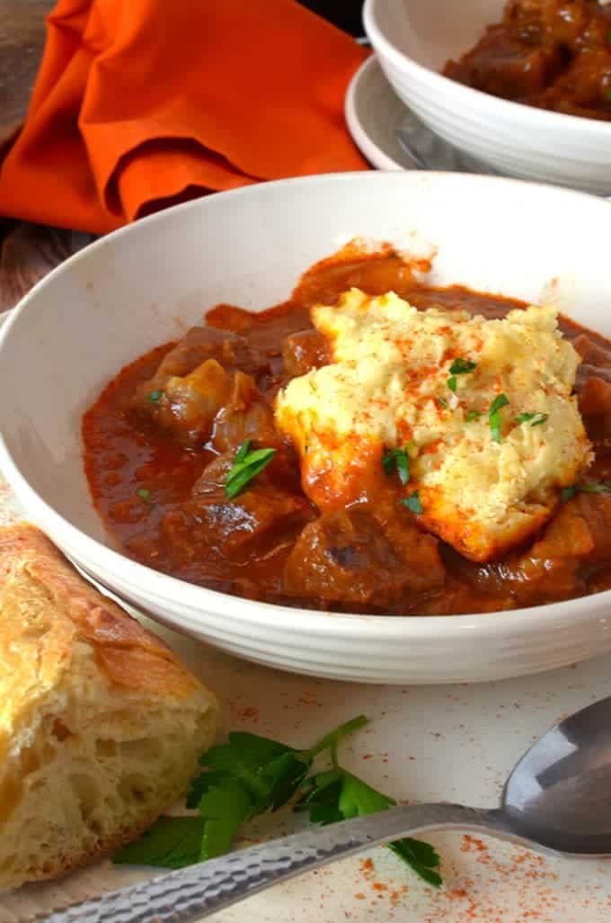 Bowl of Hungarian beef stew with steamed dumplings.