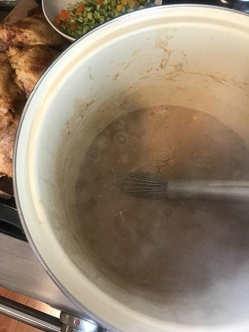 Adding roux to make sausage and chicken gumbo.