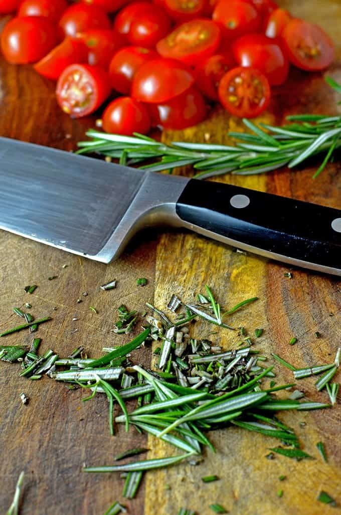 Rosemary and cherry tomatoes are used as a topping for this caulifloewer latkes recipe.