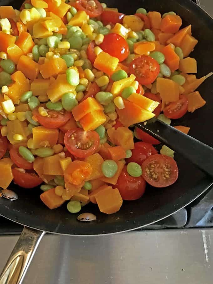 Skillet full of succatash ingredients.