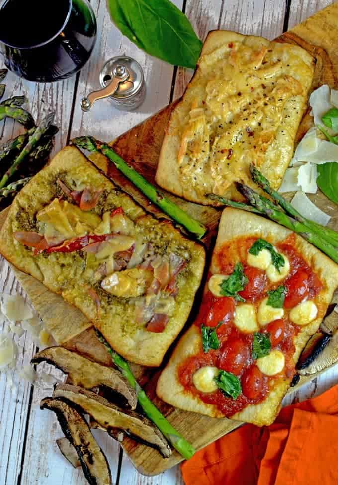 Varieties of grilled pizza on cutting board