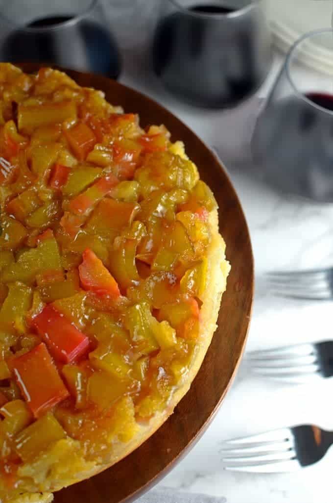 Ruhubarb cake with three glasses of red wine and three forks.