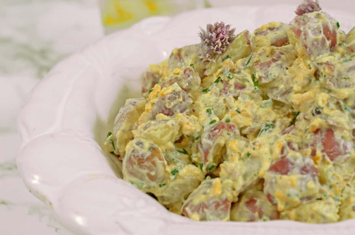 Some potato salad in a white bowl.