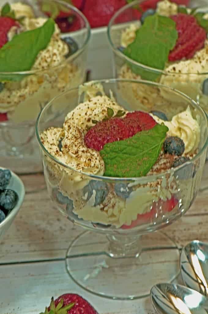 Masacarpone strawberry mousse in glass coupes on table with garnish