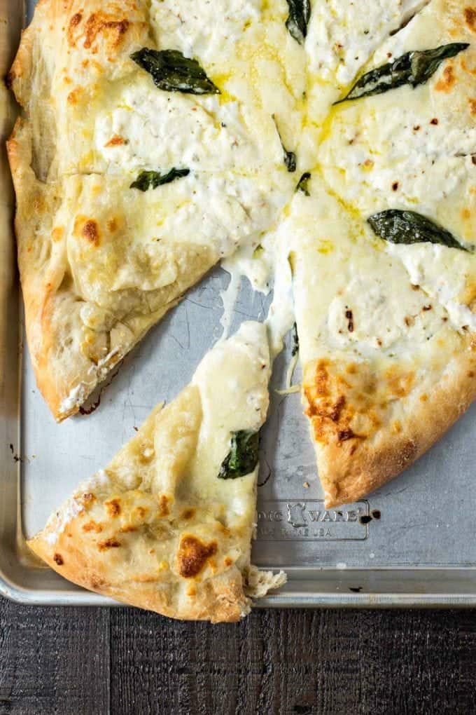 Slices of white  pizza on baking sheet