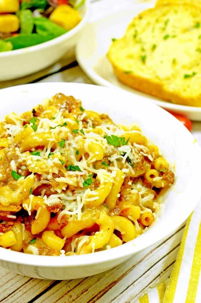 Serving of sloppy Joe mac on cheese with garlic bread on table